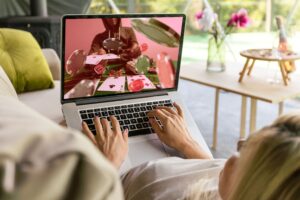 frau liegt auf dem sofa und spielt online poker am laptop